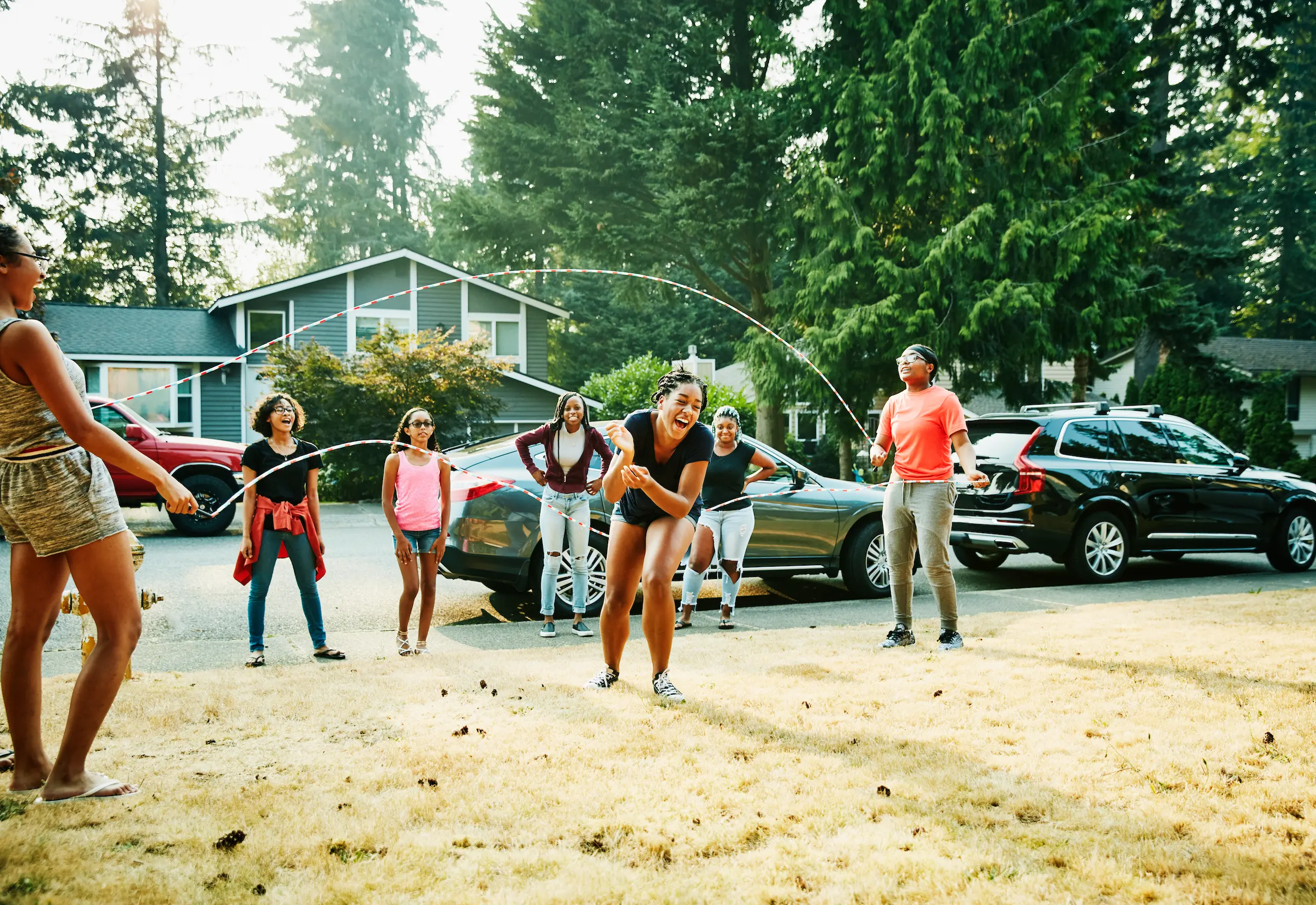 Young girls playing double-dutch in suburban neighborhood